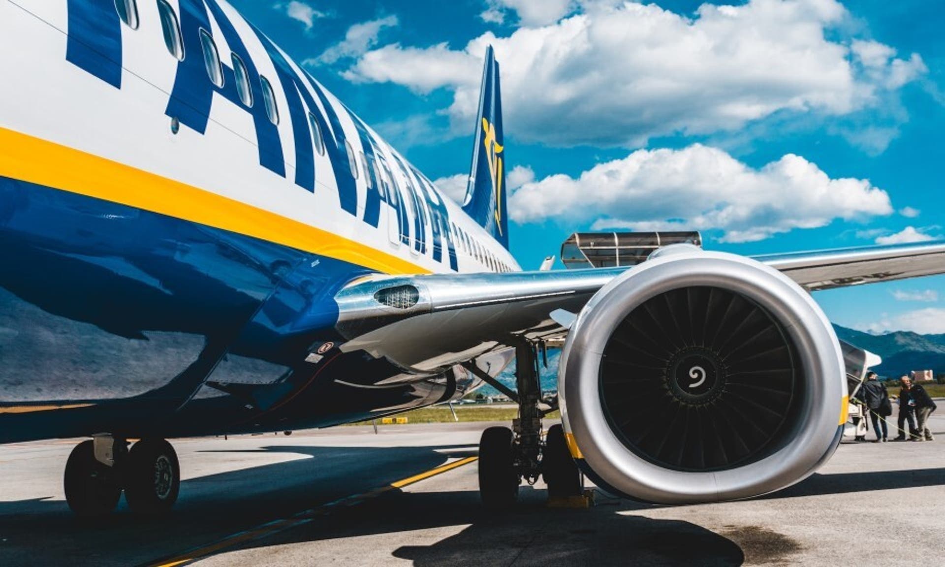  Image of a Ryanair plane sitting on an airport runway on a sunny day 