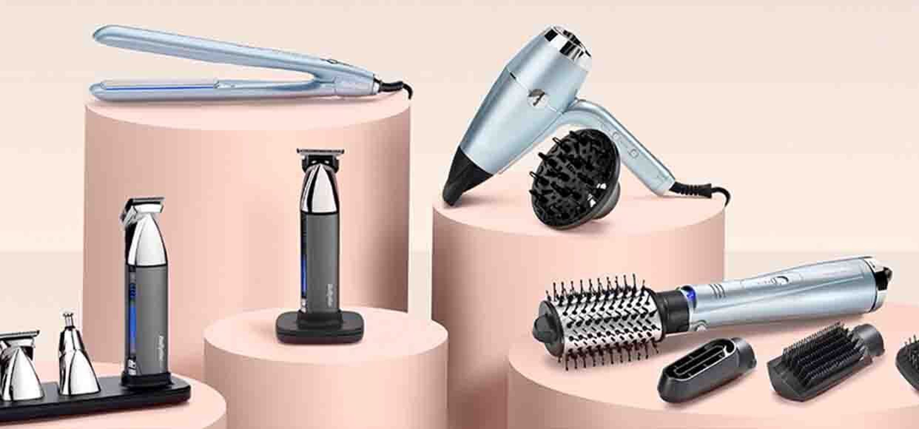 Selection of hair tools on a soft pink background
