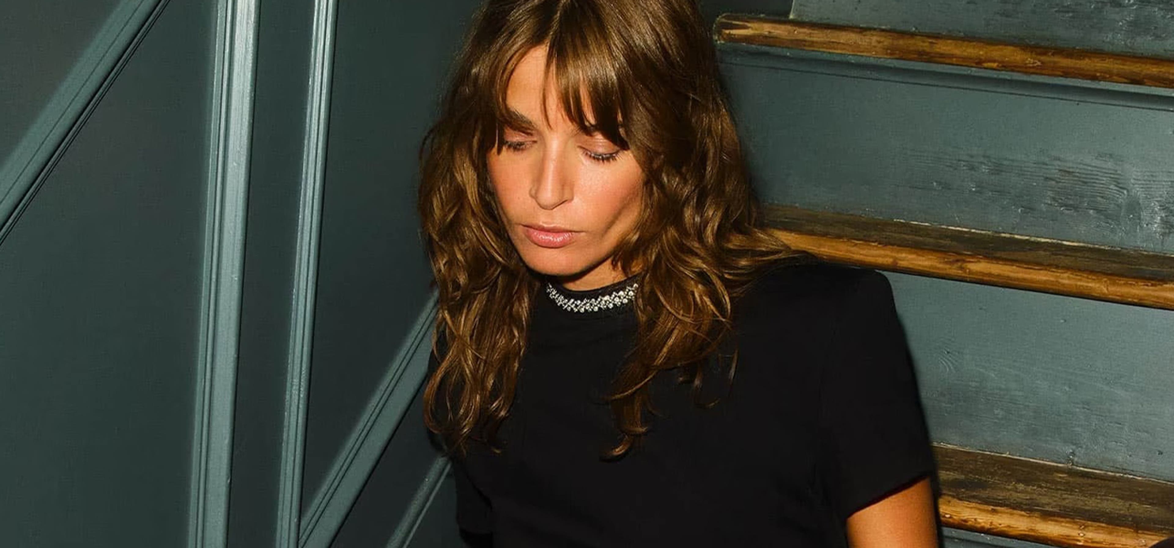 woman posing in a black dress on a staircase