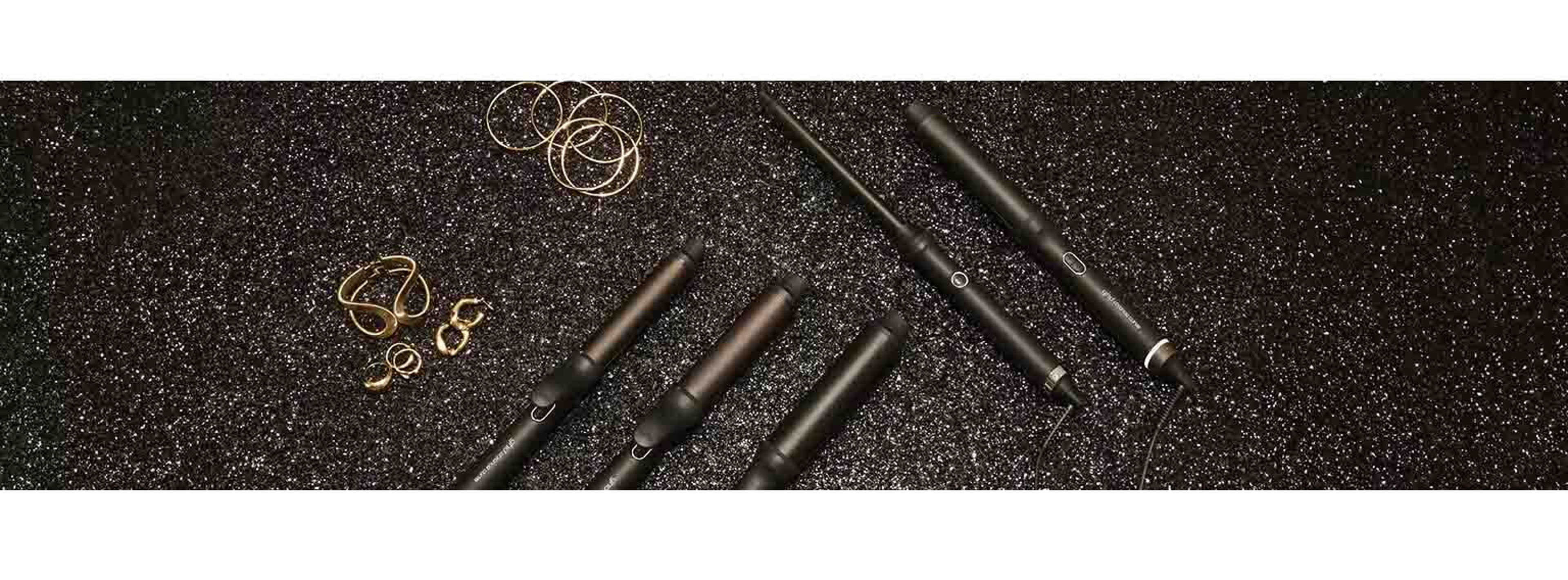 Black sparkly background with GHD hairtools and gold jewellery