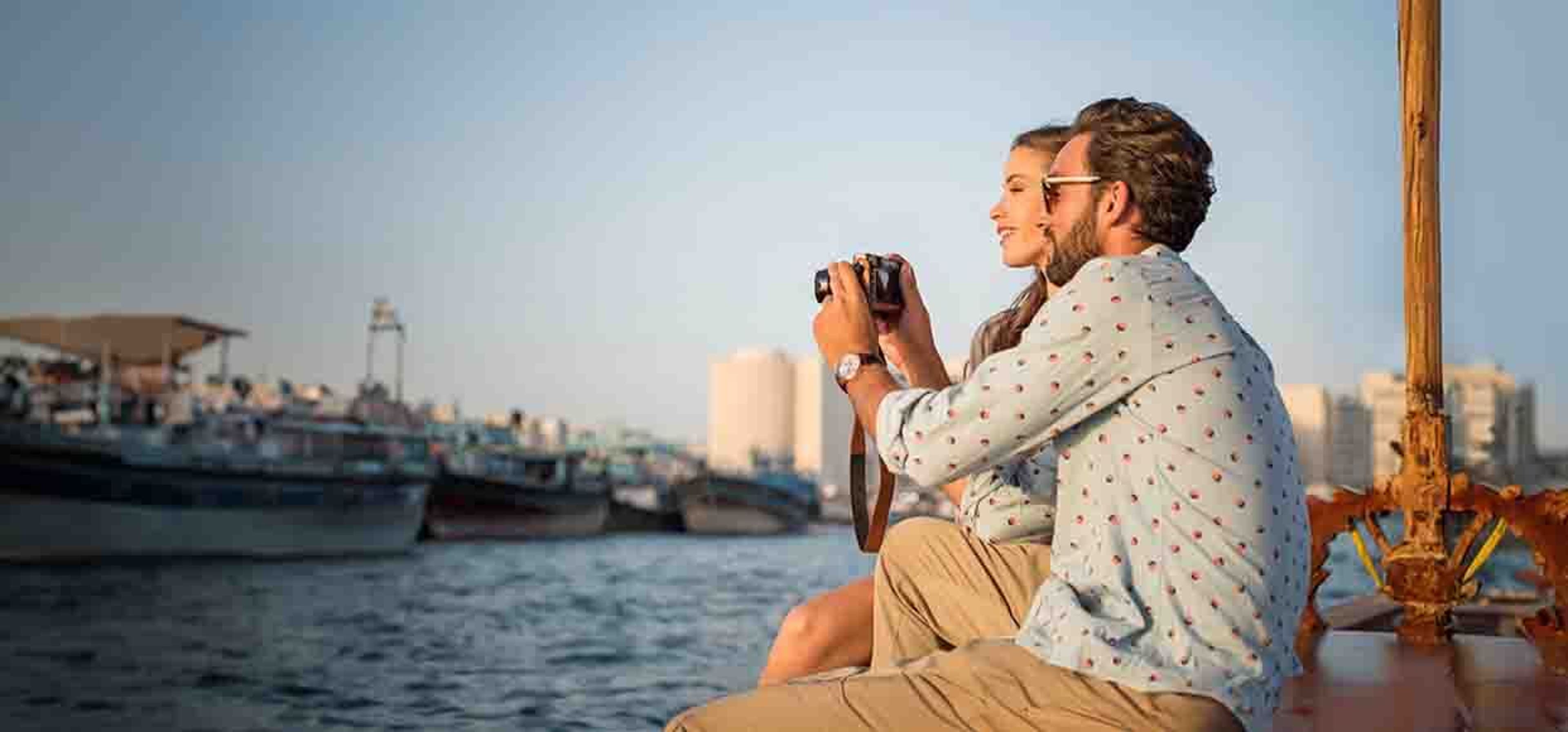couple posing and taking photos sitting on the edge of a bank