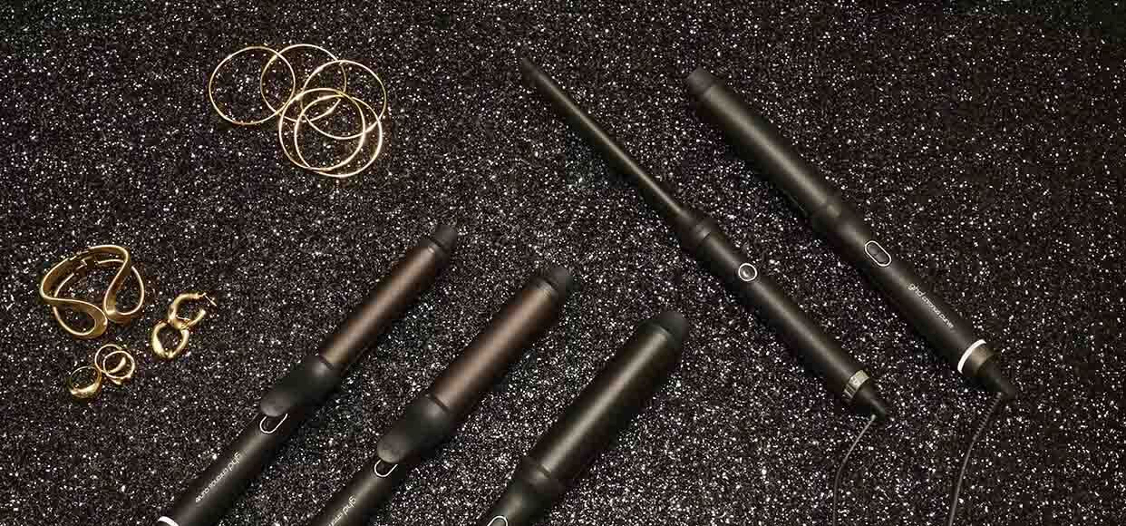 Black sparkly background with GHD hairtools and gold jewellery