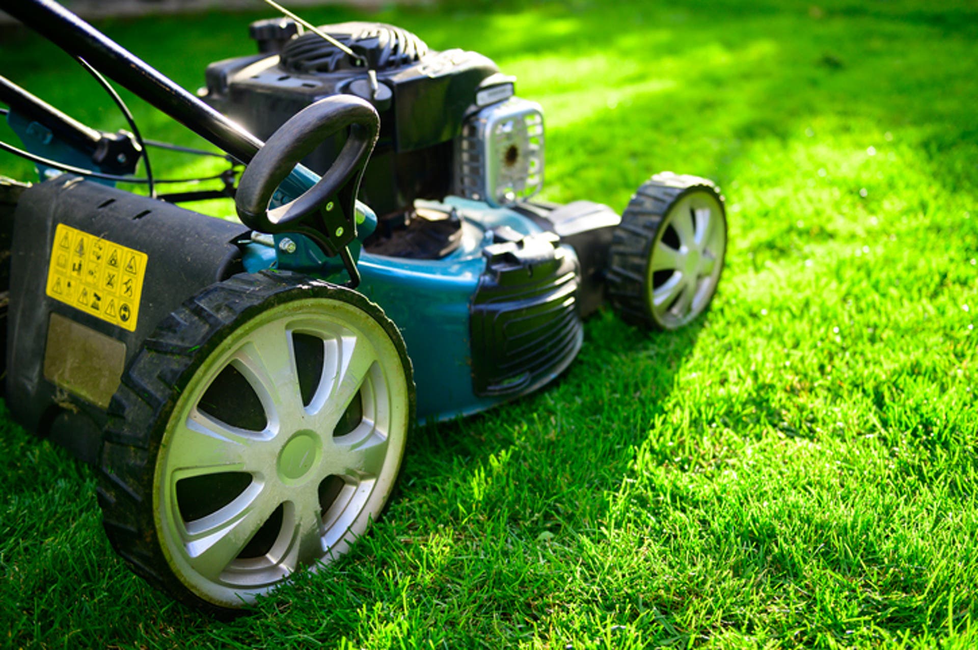  Lawn mower on green grass in a sunny day 