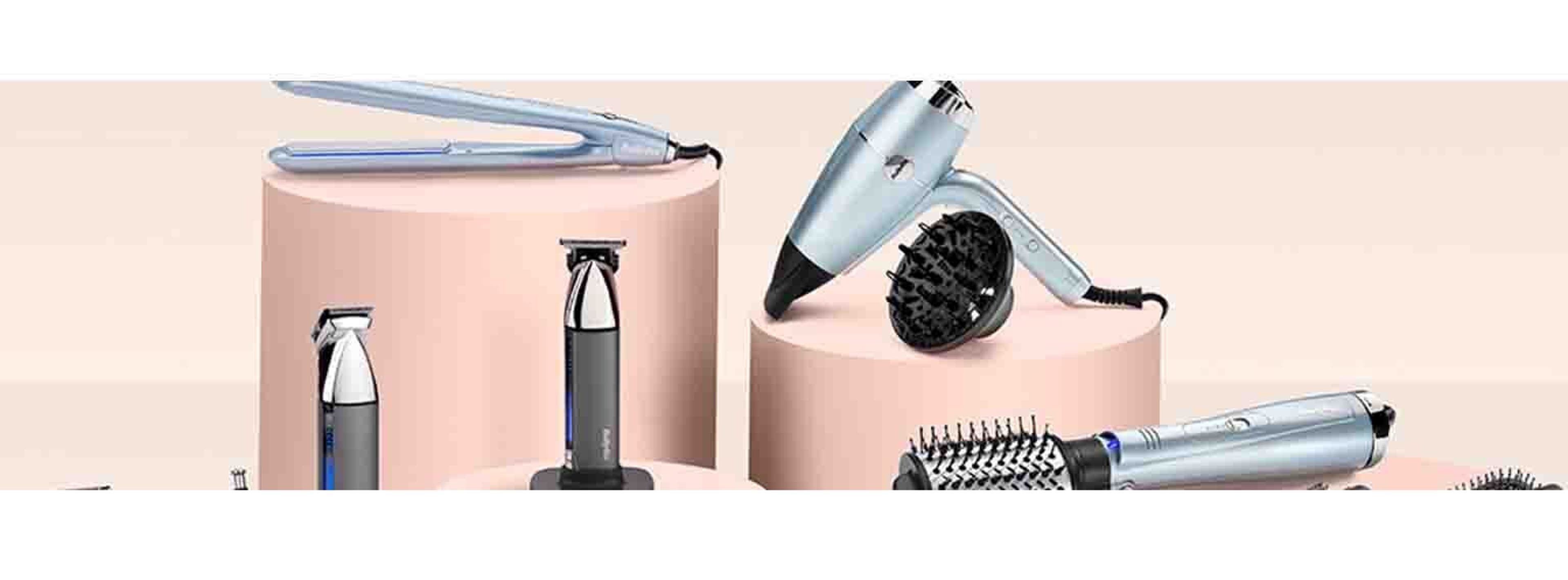 Selection of hair tools on a soft pink background