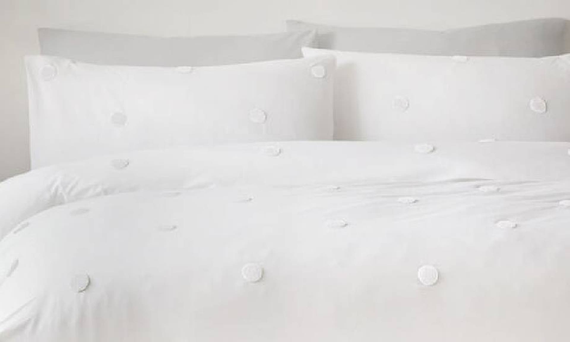  White bedding with white textured spots on a duvet and pillows from Cotton Traders 