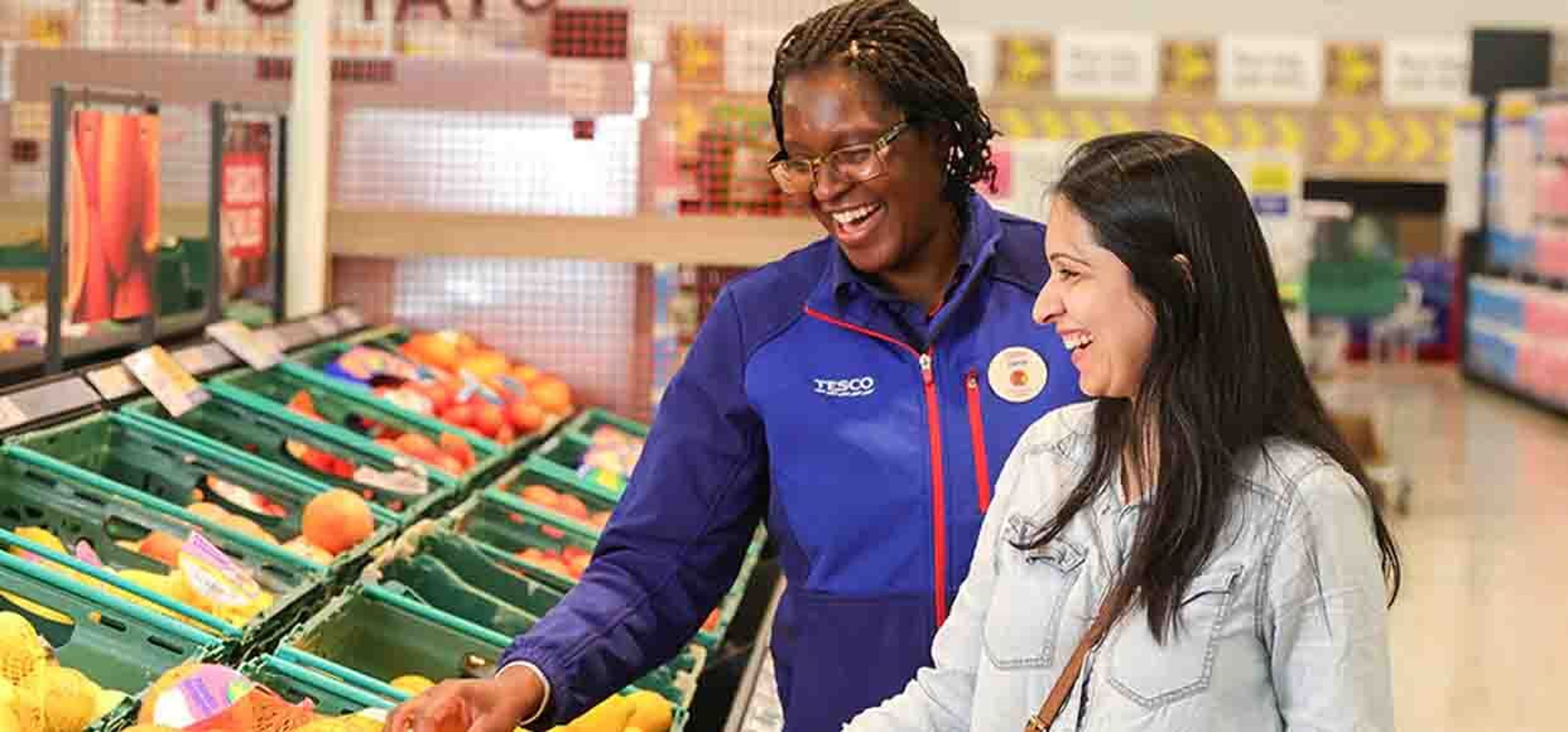 tesco helper and customer looking happily at veg