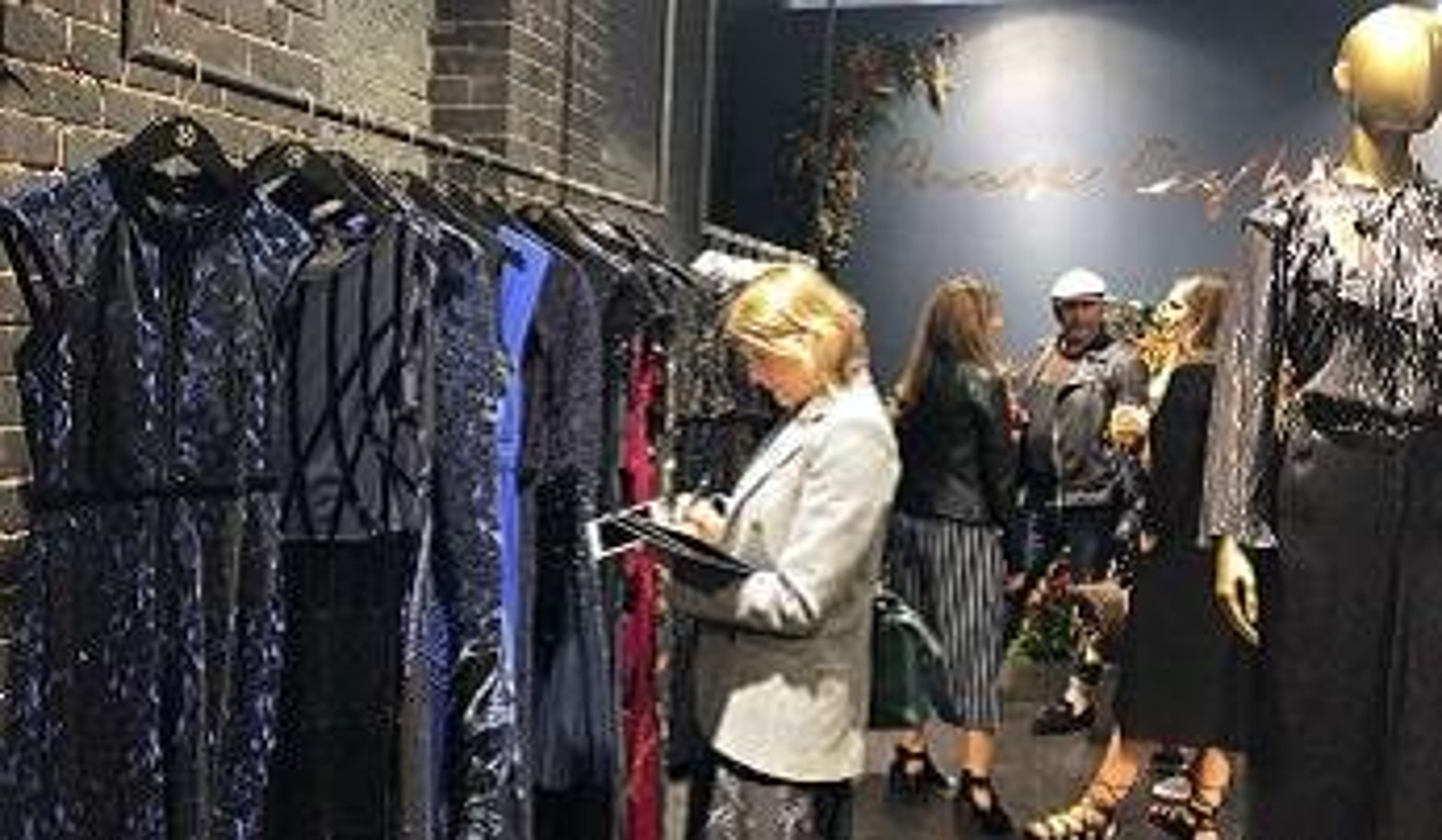  A woman looking at dresses in a Phase Eight store 