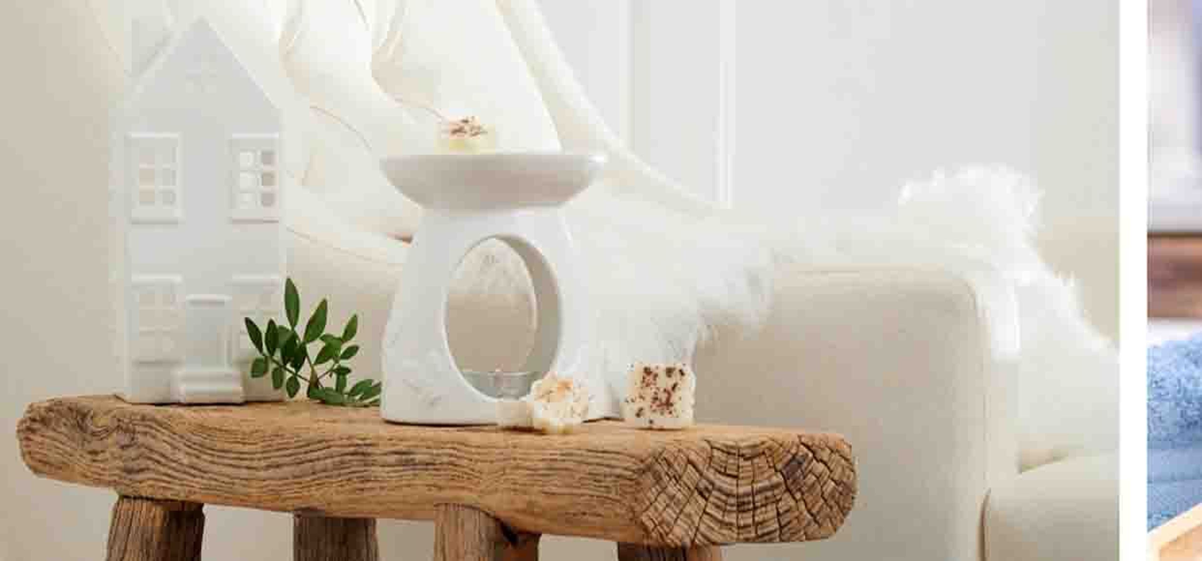 Candle on a side table next to a white chair