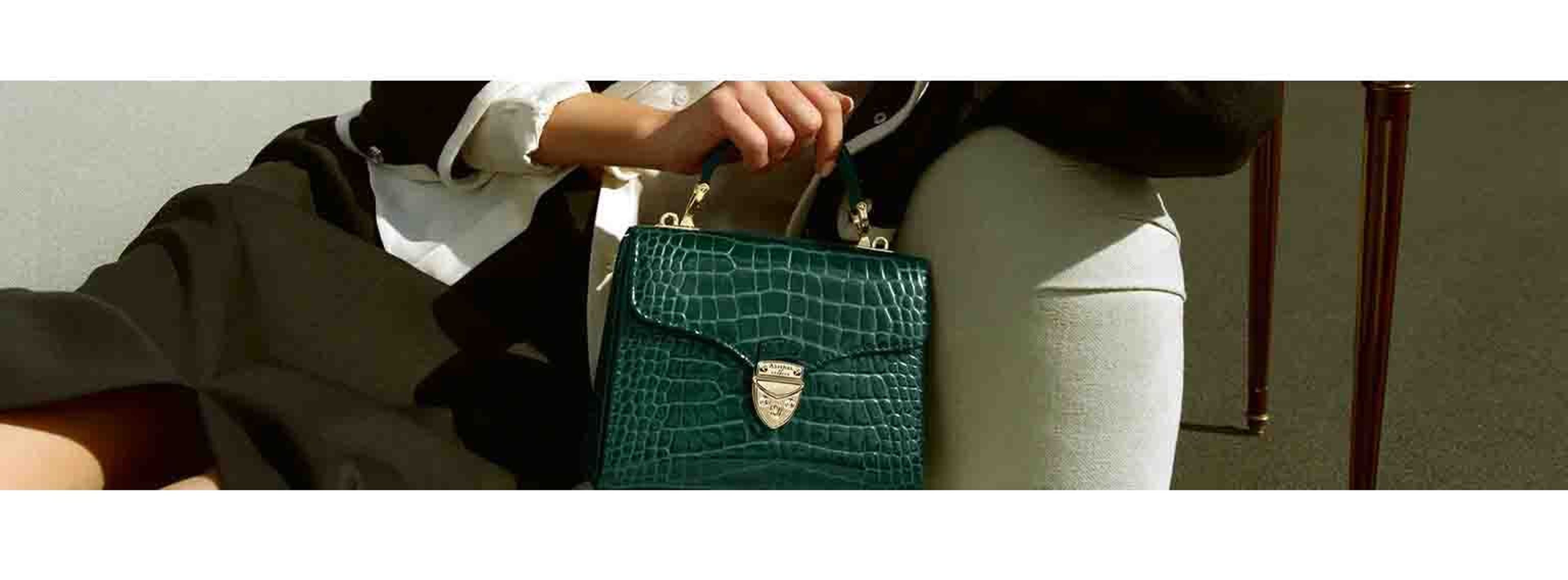 Image of woman posing with a green small handbag