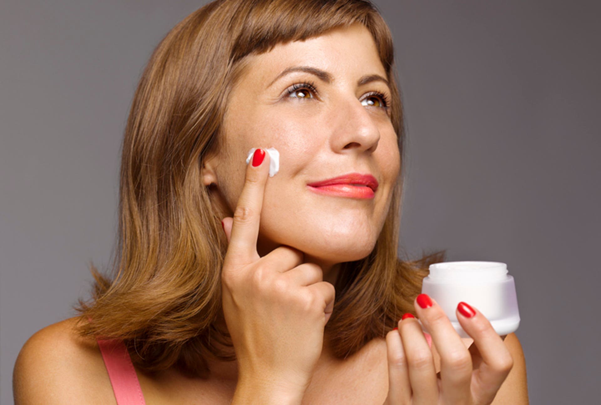  Woman applying face cream at the end of the day 