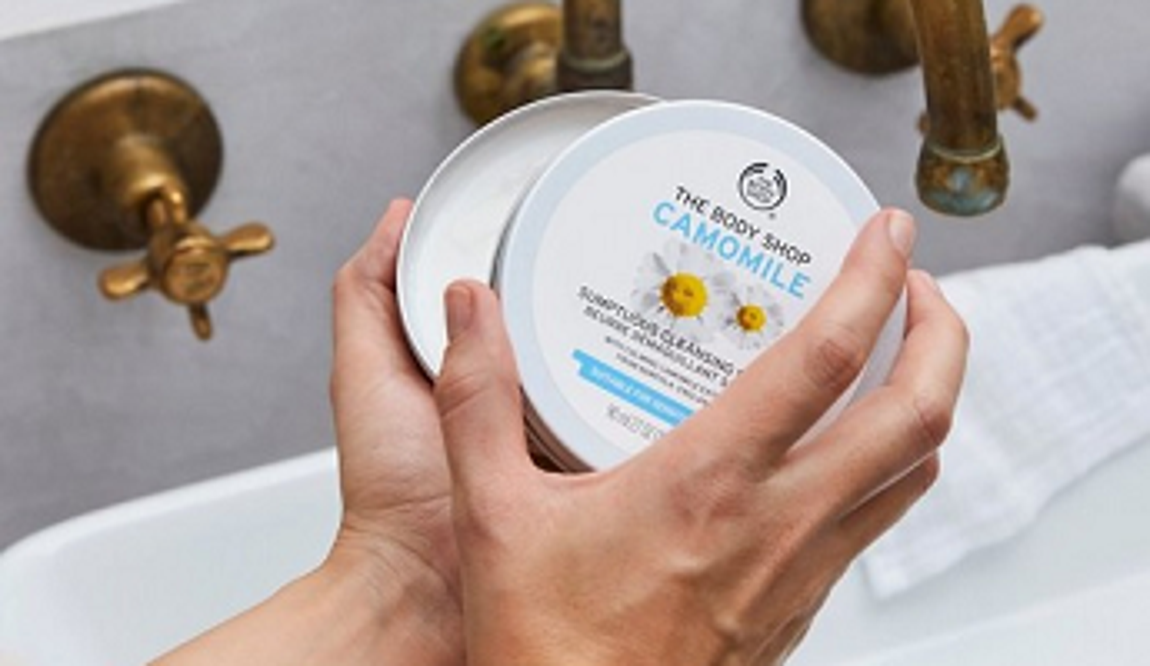  The Body Shop Camomile Cleansing Butter being opened near taps 