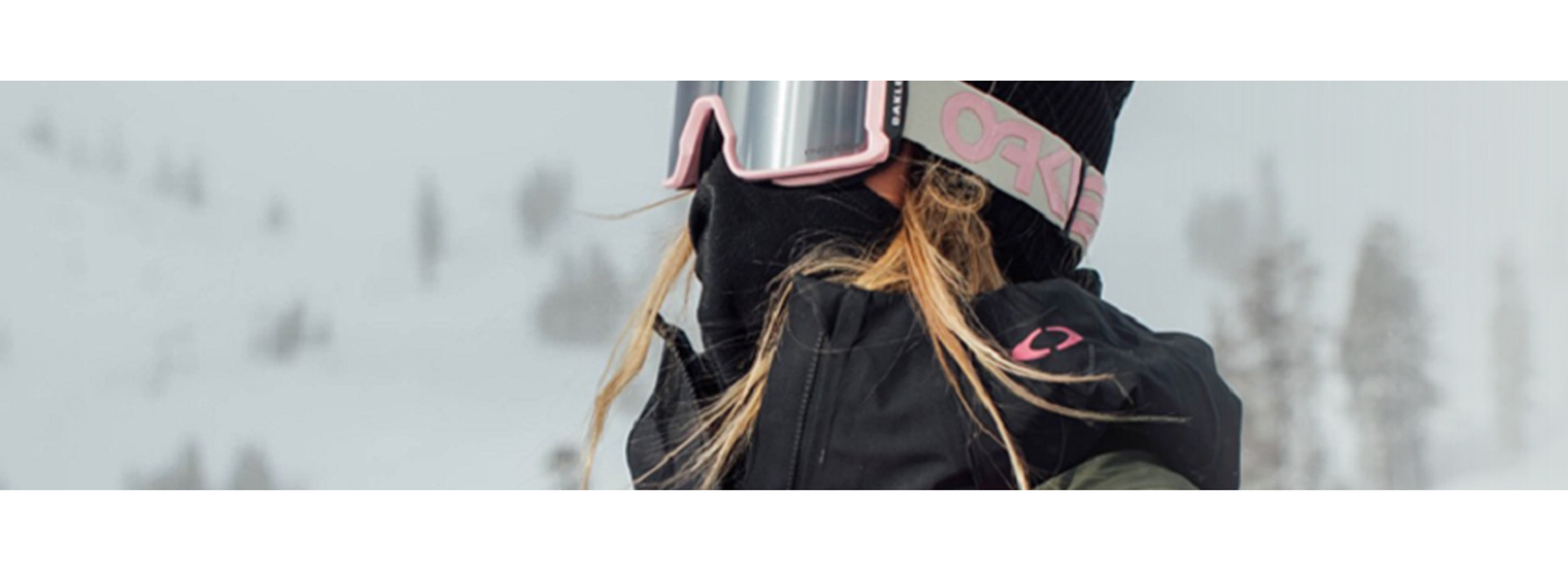 Woman skiing wearing Oakley merchandise in grey and pink