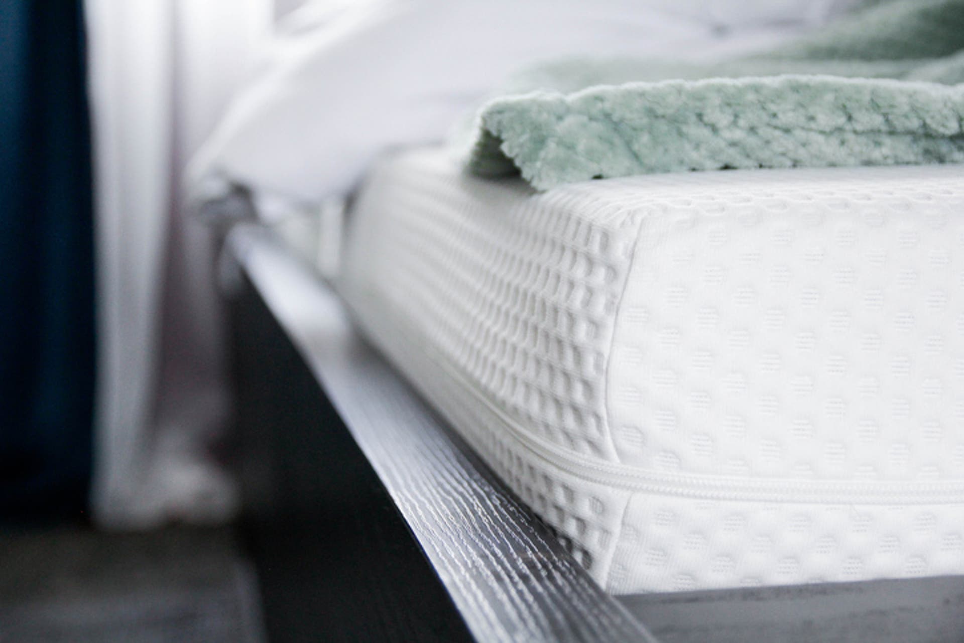  an angled picture of a mattress with bedding on top 