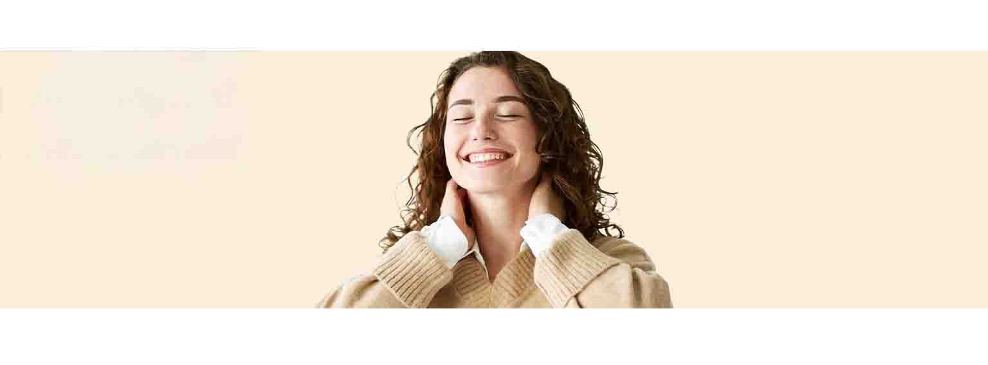 Woman smiling and raising her arms on a cream background