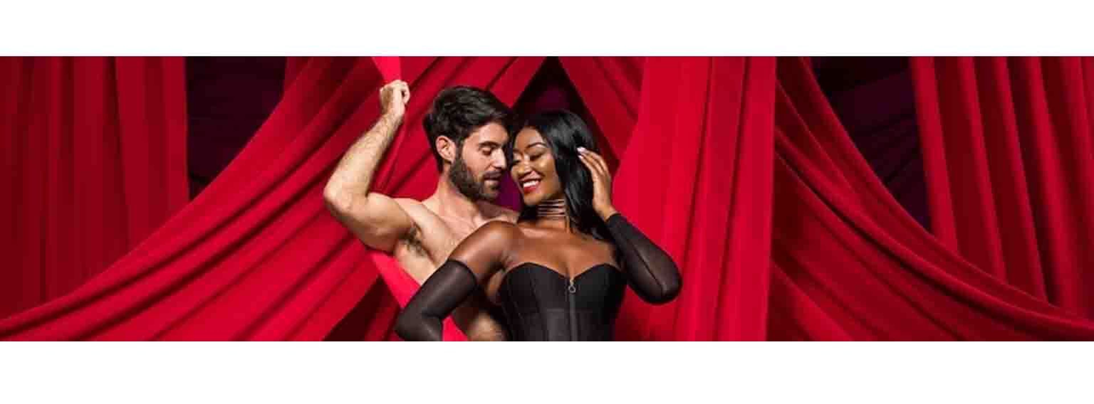 two people posing with red curtains