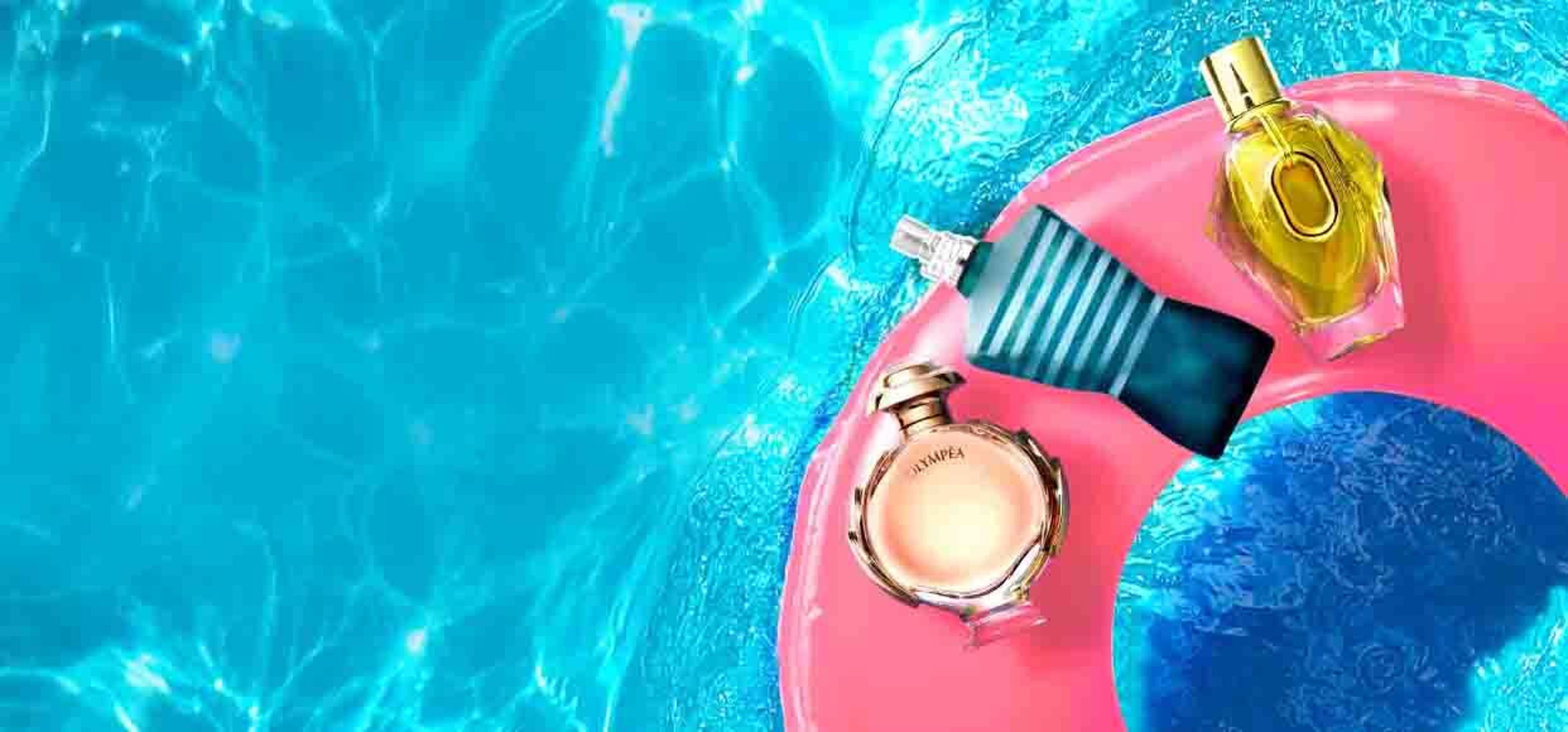 a collection of perfumes in a pink rubber ring floating in a pool