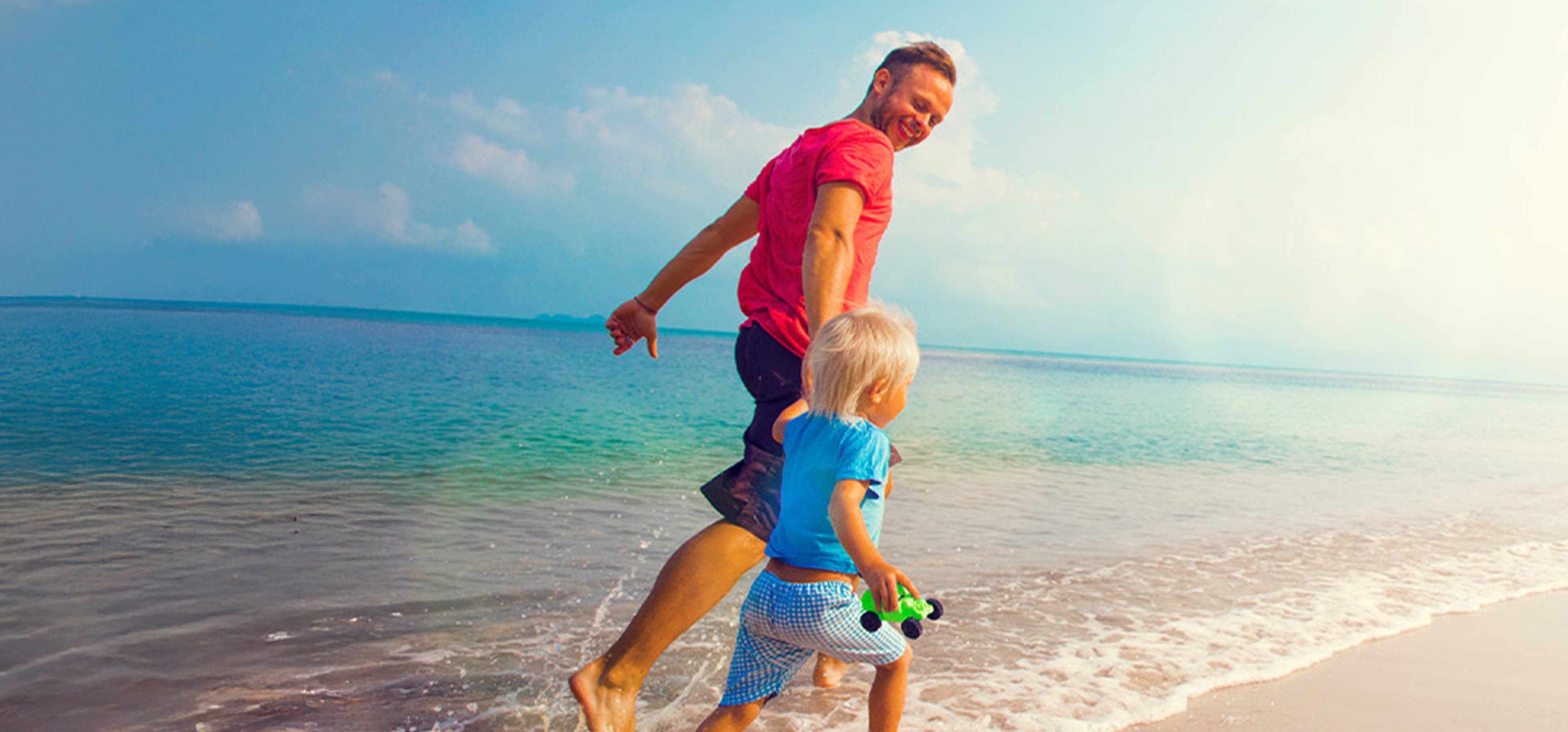 son and dad running on the beach
