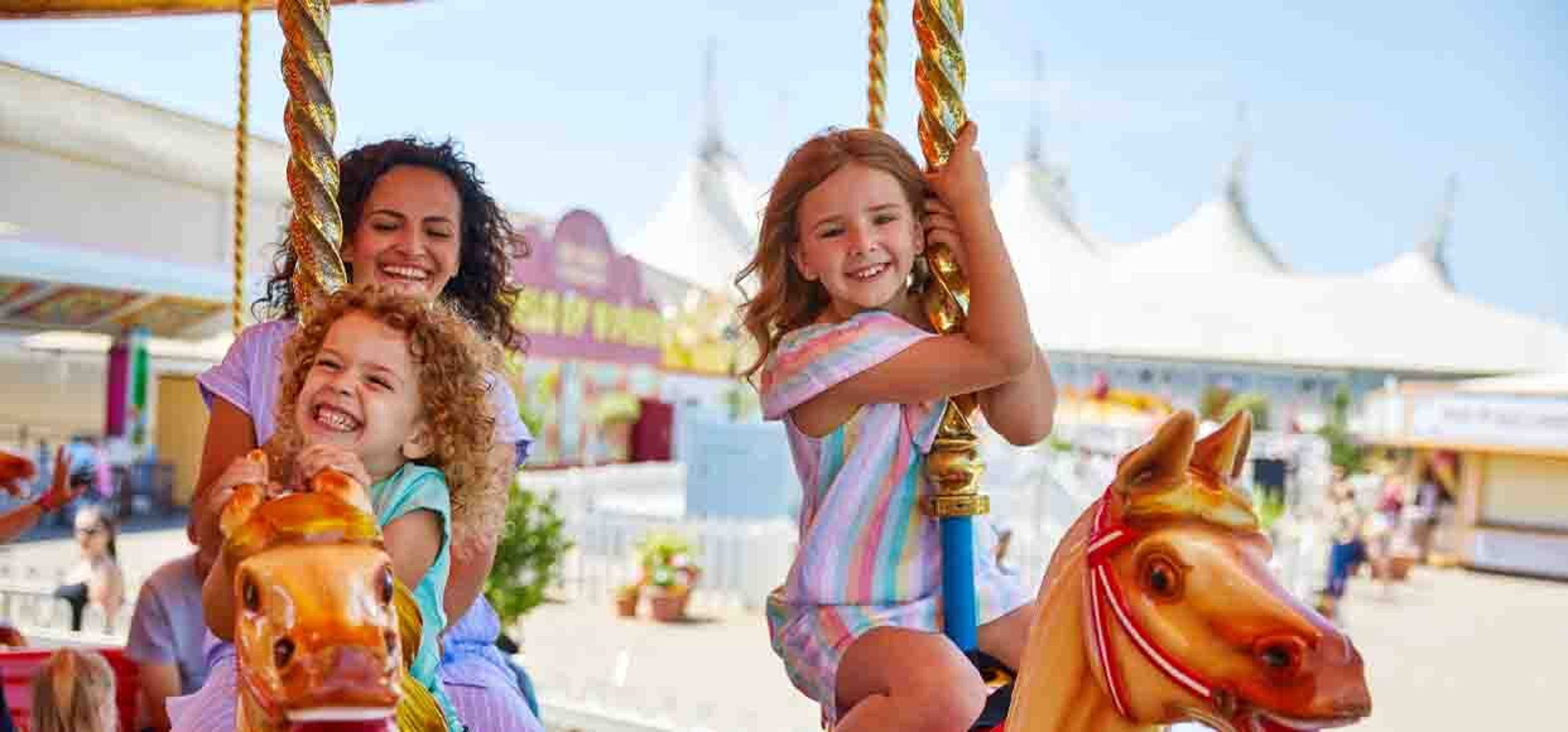 two young girls on a carousel