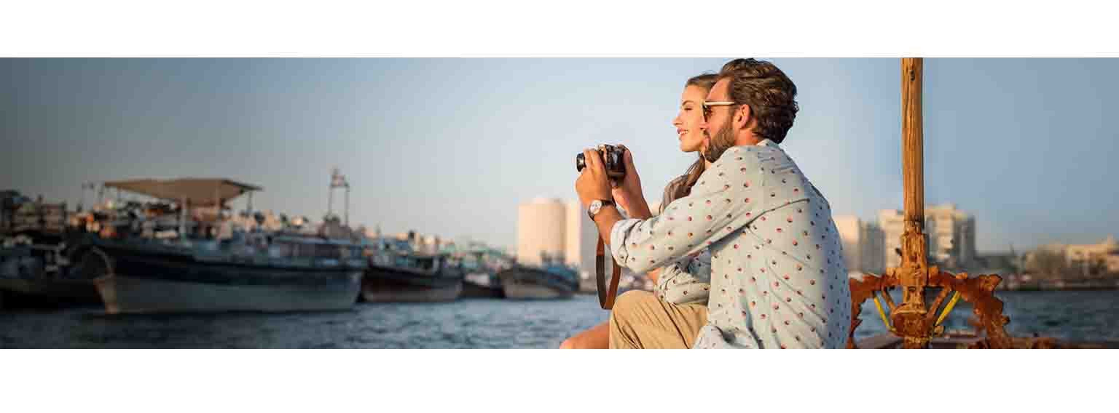 couple posing and taking photos sitting on the edge of a bank
