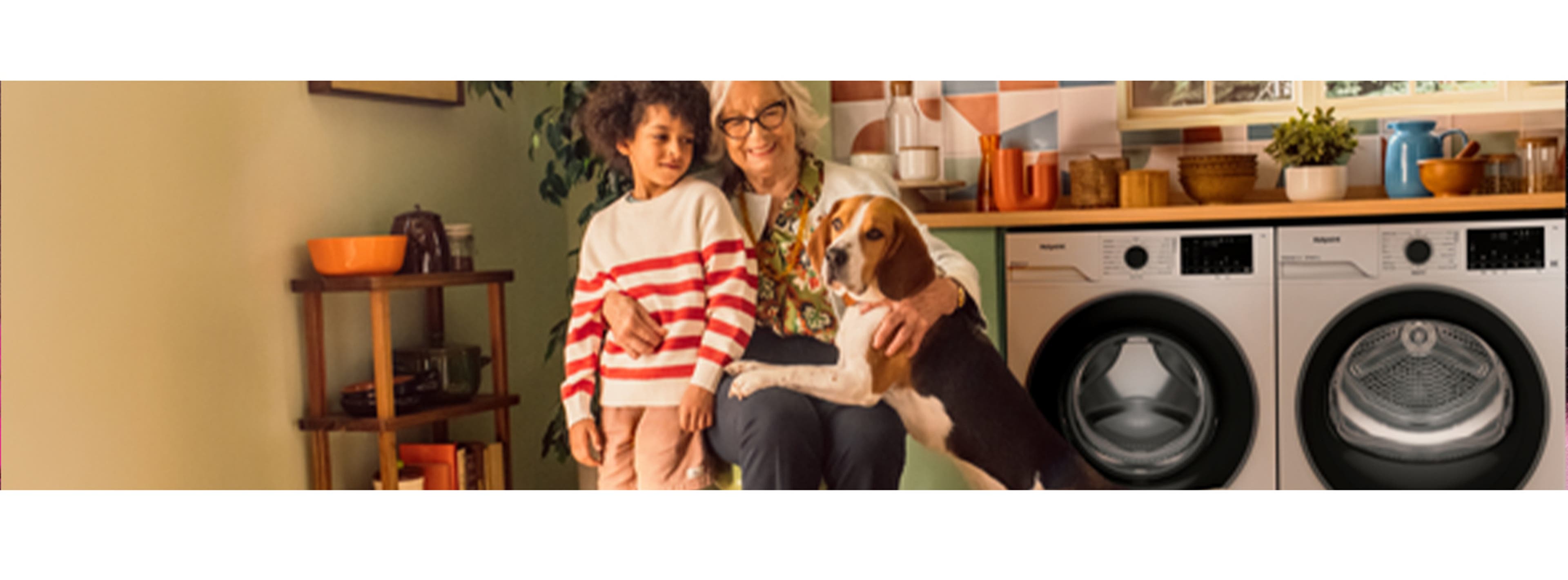 Grandmother hugging her grandson and dog in the kitchen