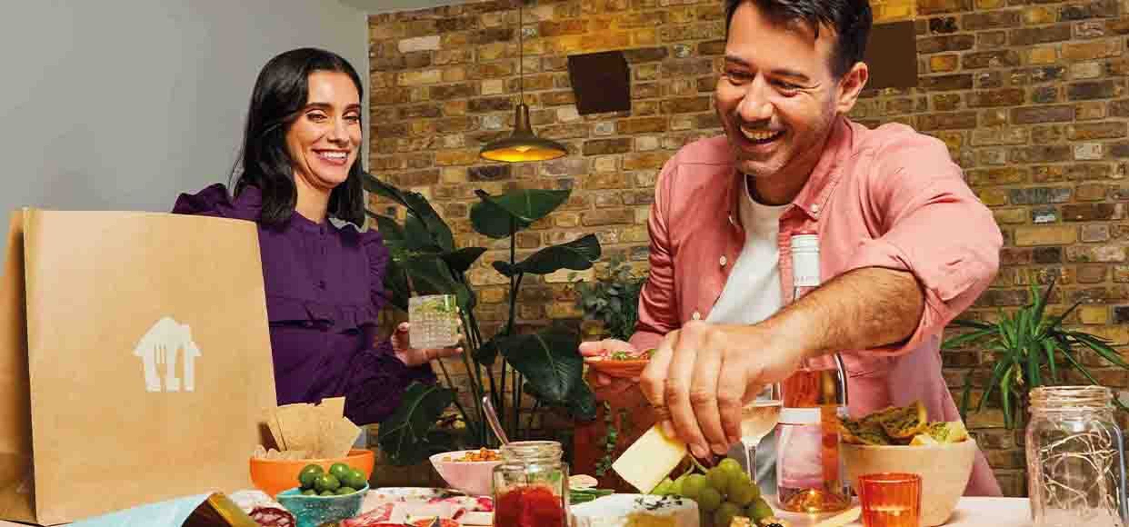 two people unpacking food in the kitchen