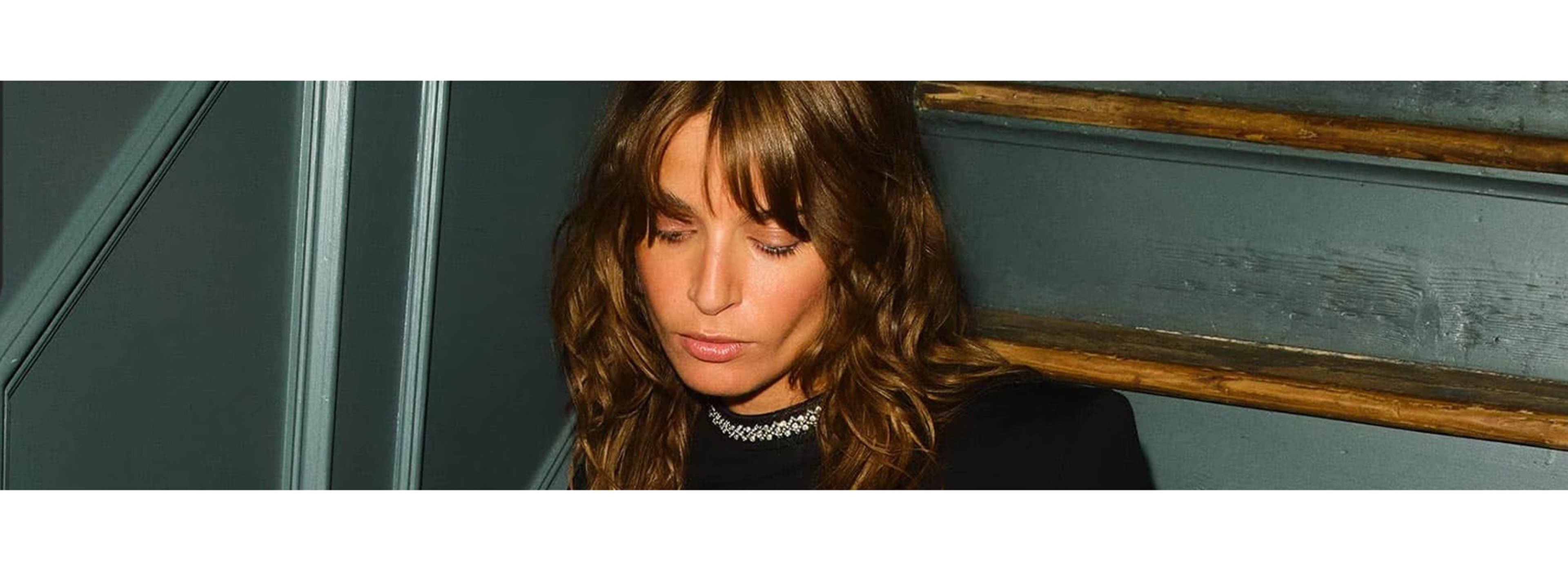 woman posing in a black dress on a staircase