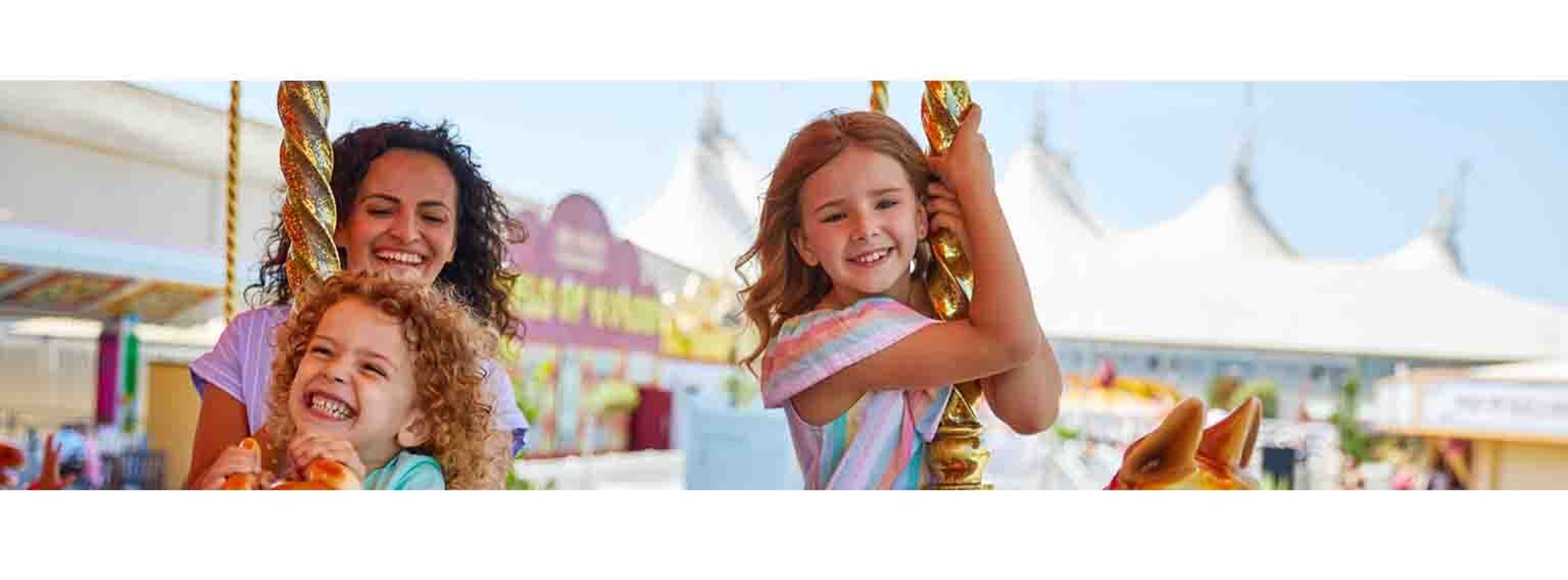 two young girls on a carousel