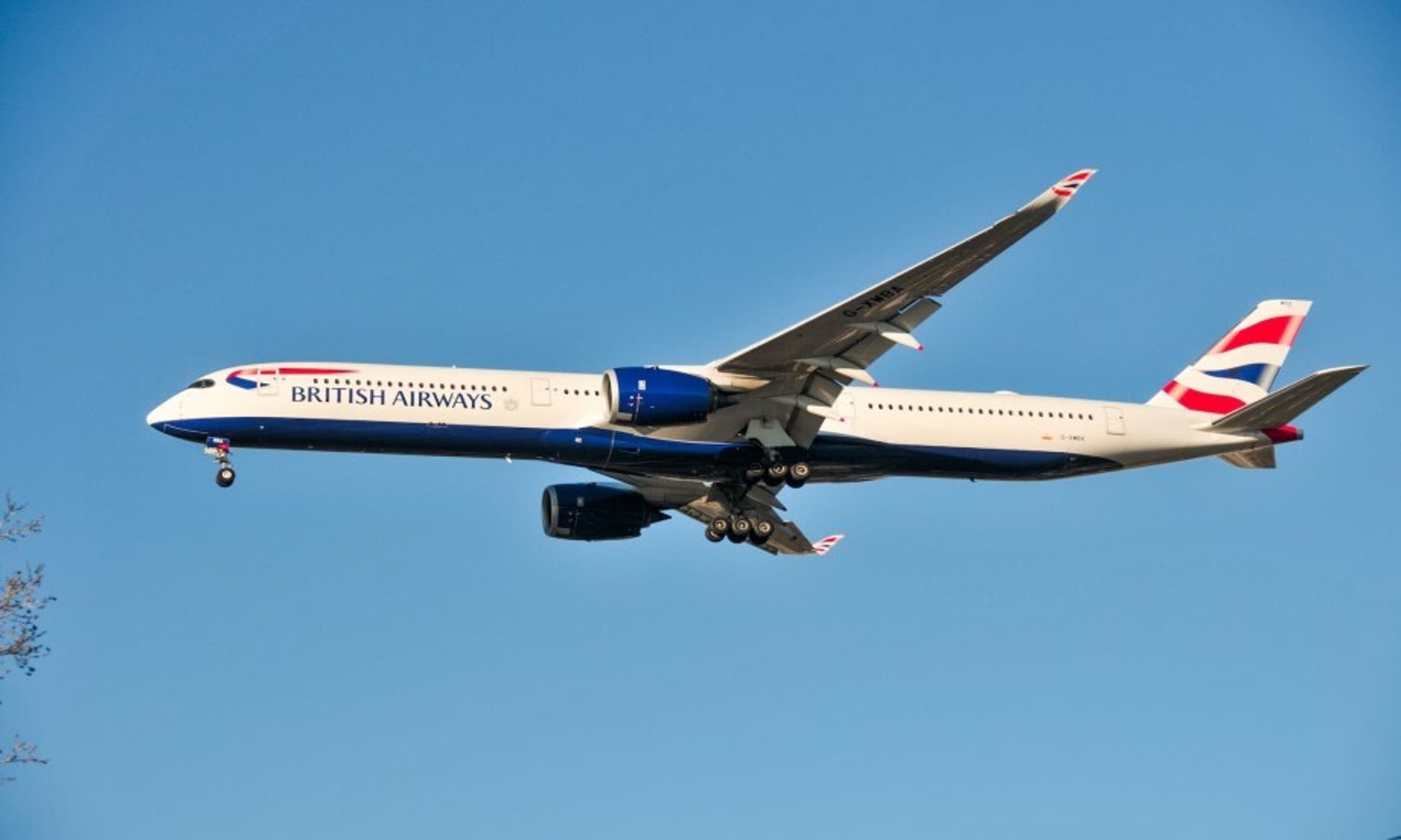  British Airways plane flying through the sky on a sunny day 