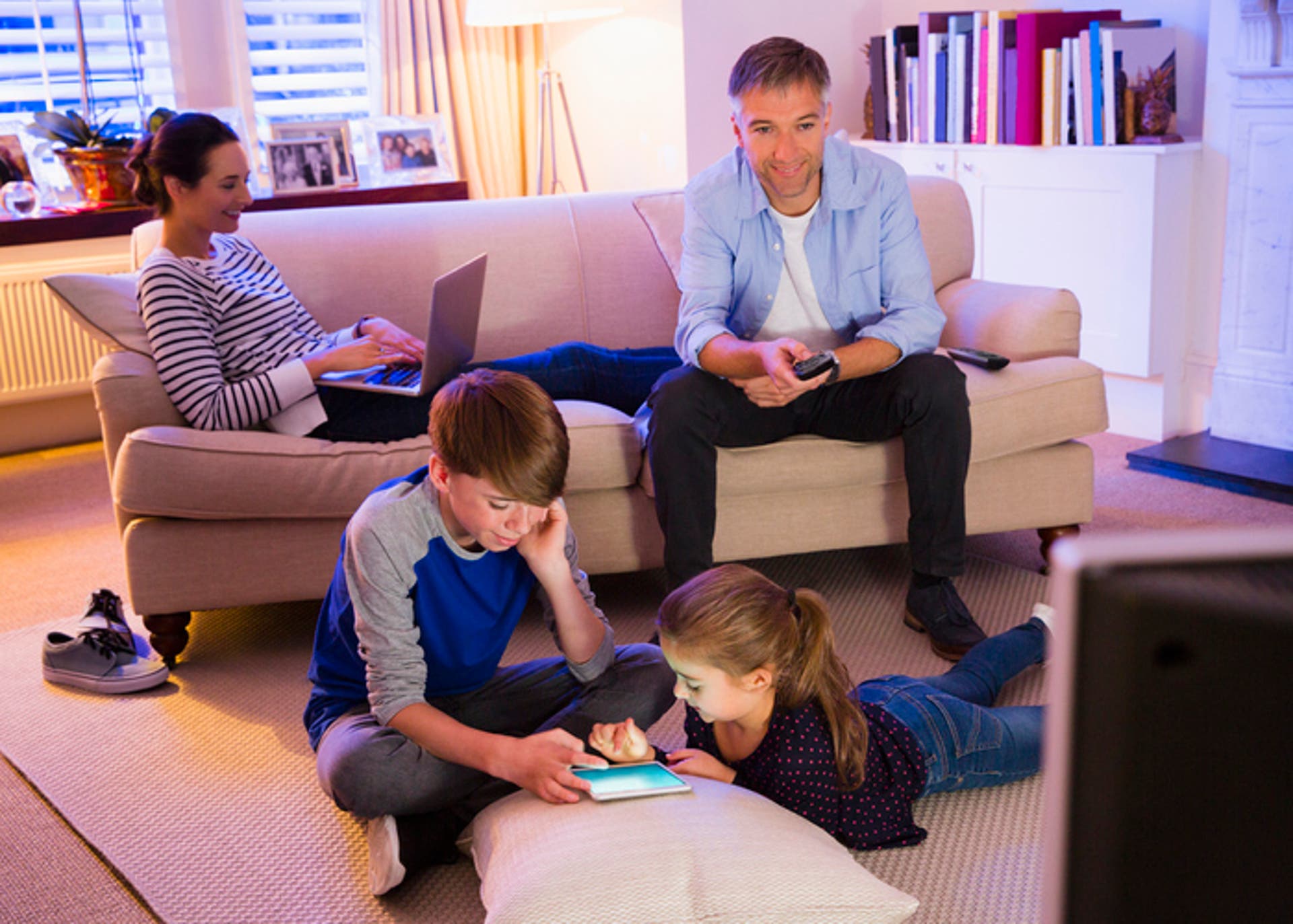  Family relaxing with technology in living room 