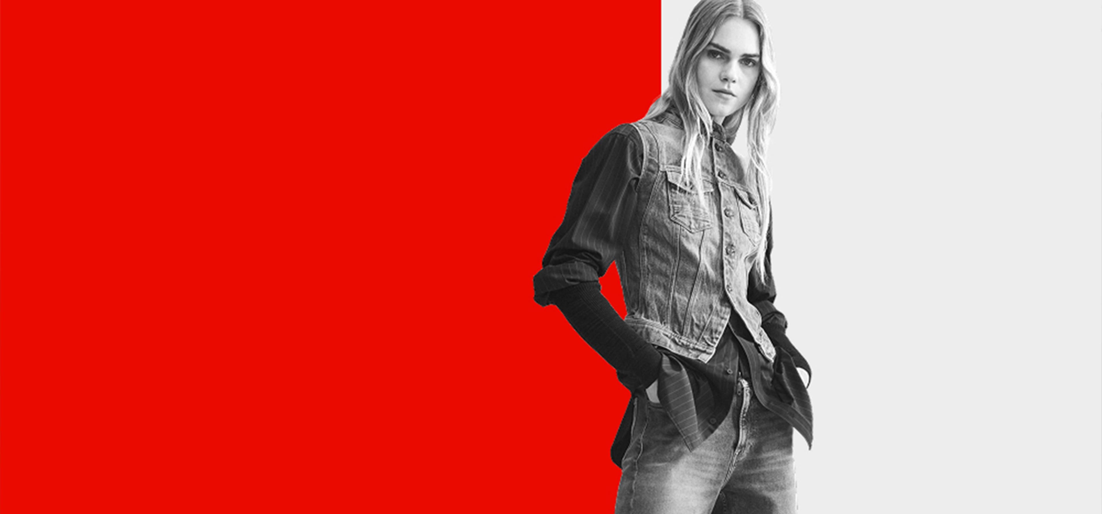 Model posing in denim in front of an abstract background of red and white