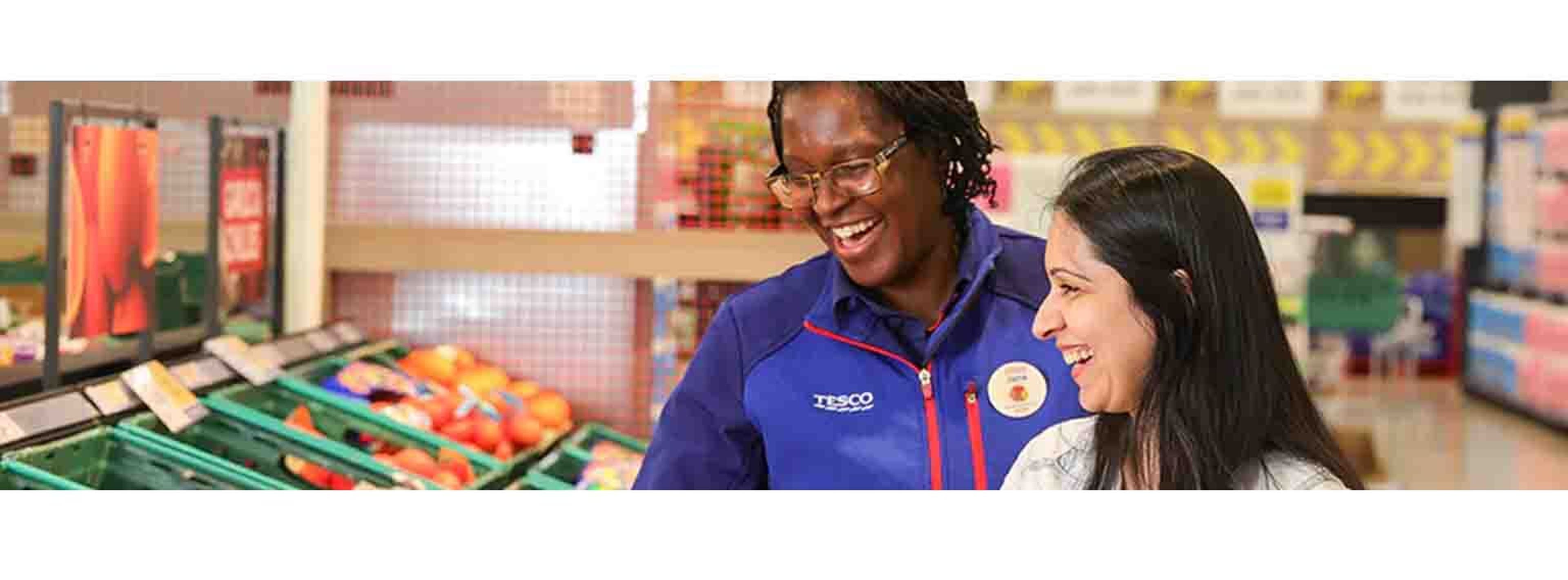 tesco helper and customer looking happily at veg