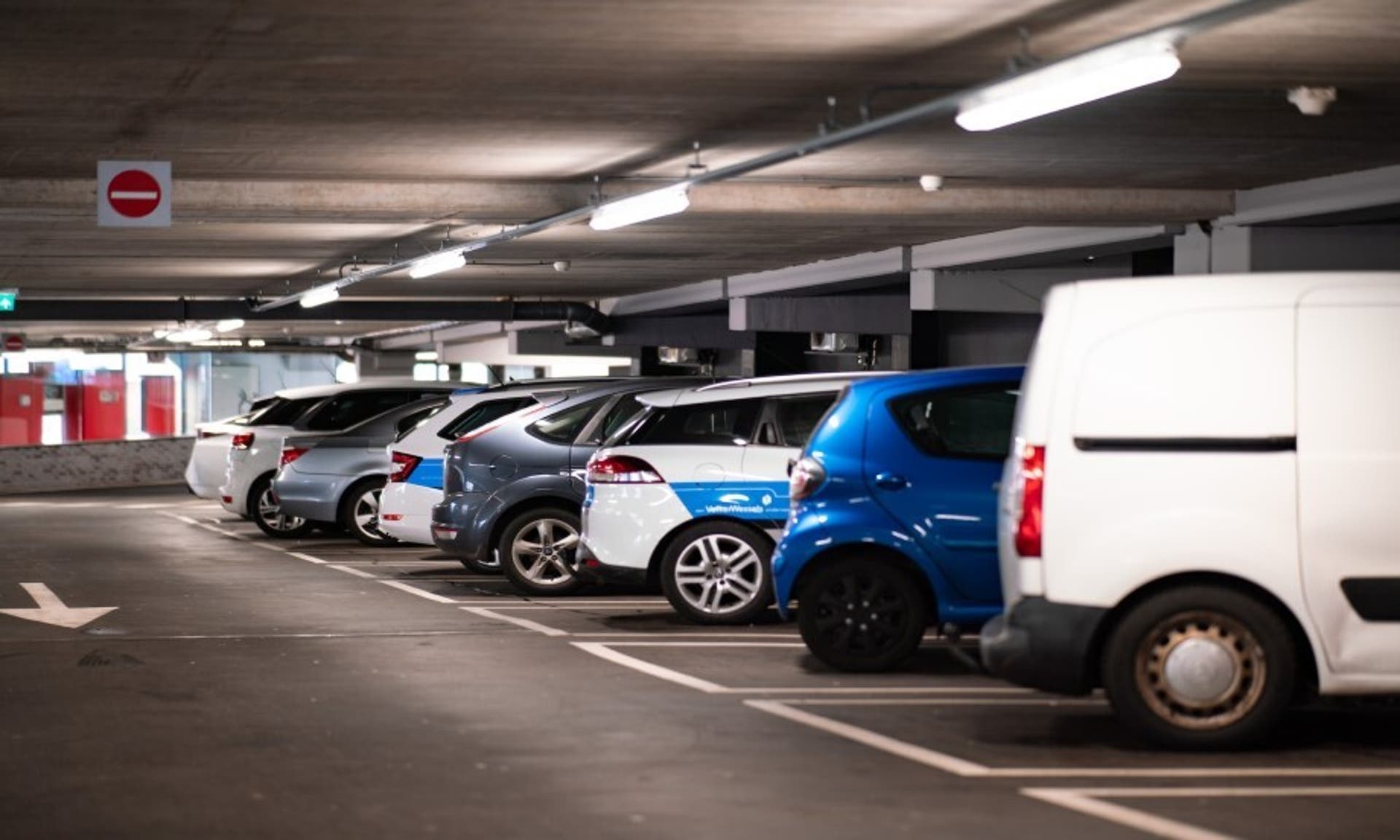  image of an airport car park, with cars parked in a row 