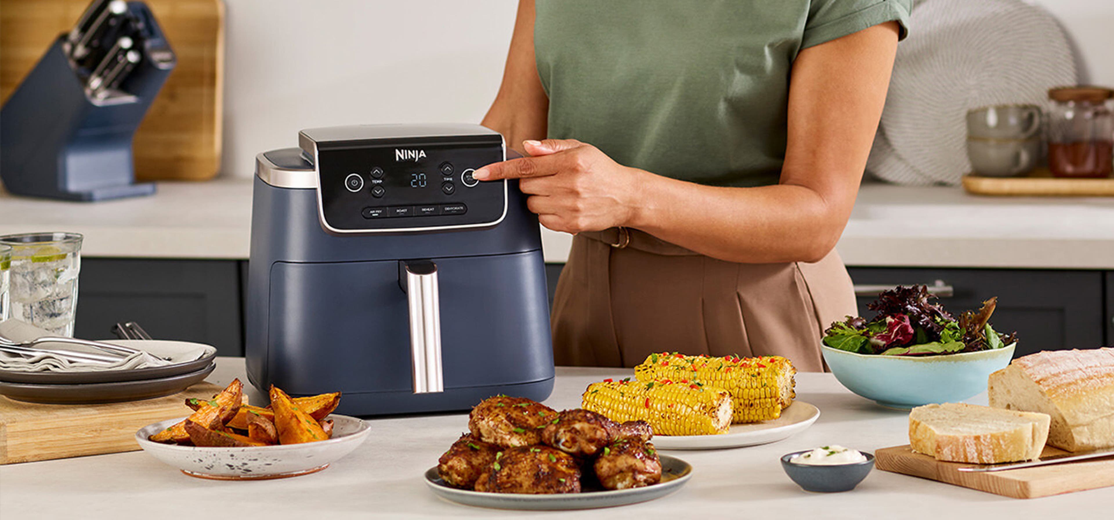 woman pressing a button on the ninja aryfryer machine