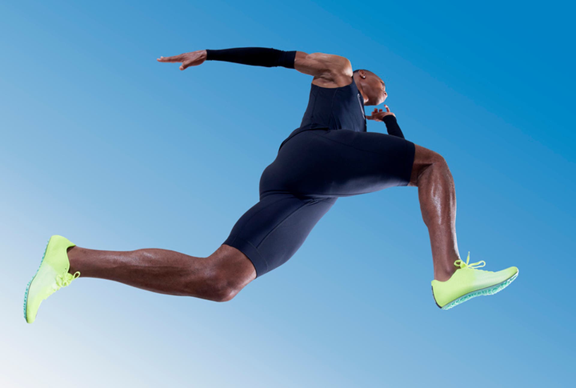  Low angle view of professional athlete sprinting against blue sky. 